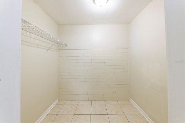 walk in closet with light tile patterned floors