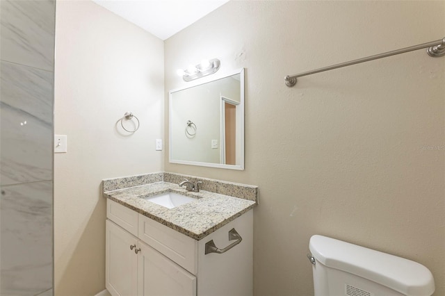 half bath featuring toilet and vanity