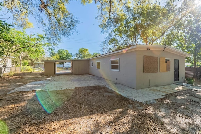 rear view of property featuring a patio, concrete block siding, and fence