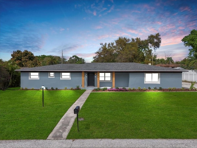 ranch-style house featuring stucco siding and a front yard