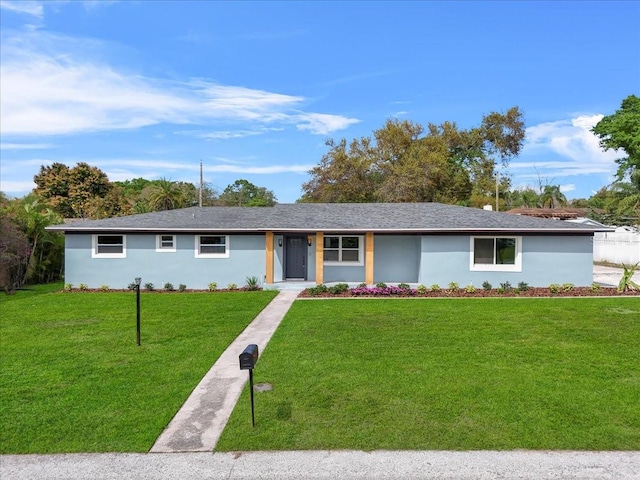 ranch-style house featuring a front lawn and stucco siding