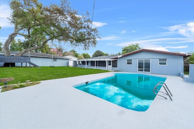 outdoor pool featuring a patio, a yard, and a sunroom