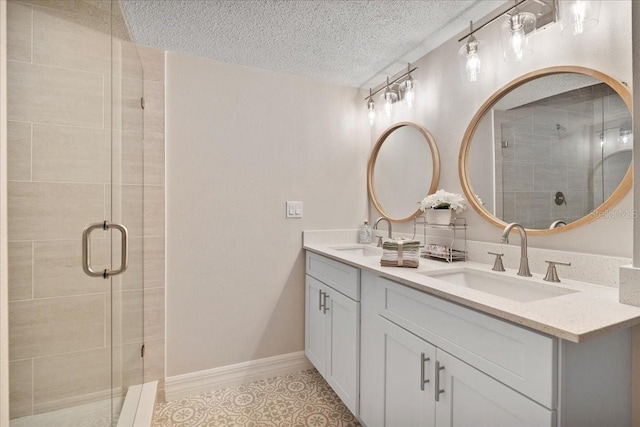 bathroom featuring a sink, a textured ceiling, and a stall shower