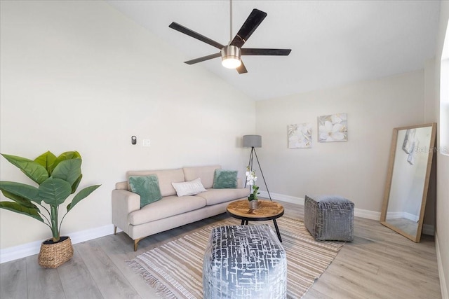 living area featuring a ceiling fan, baseboards, and wood finished floors