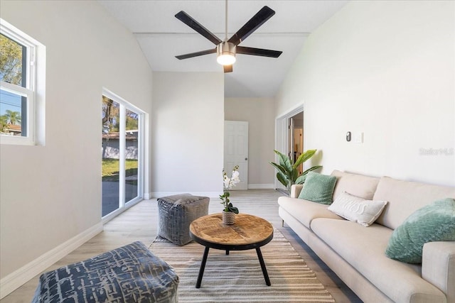 living area featuring light wood-style flooring, high vaulted ceiling, baseboards, and ceiling fan