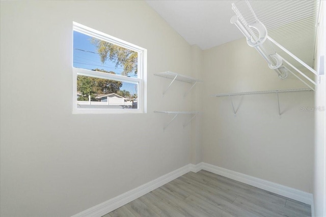 spacious closet featuring lofted ceiling and light wood-style floors