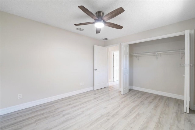 unfurnished bedroom featuring a textured ceiling, baseboards, visible vents, and light wood-type flooring