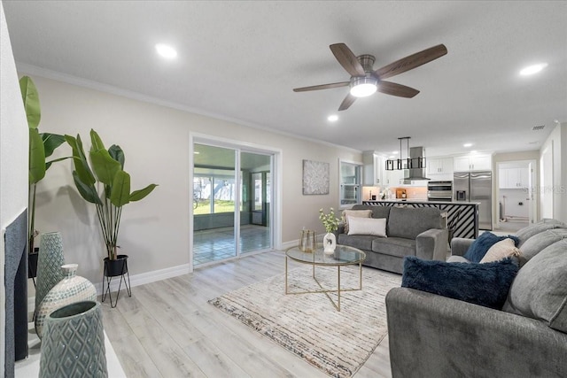 living area featuring recessed lighting, light wood-type flooring, crown molding, and baseboards