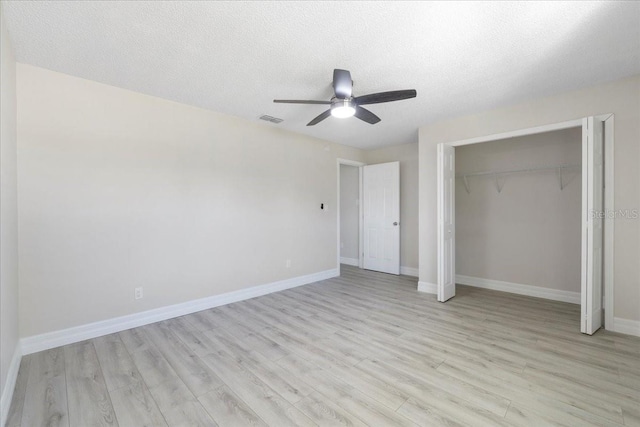 unfurnished bedroom with light wood finished floors, visible vents, baseboards, a closet, and a textured ceiling