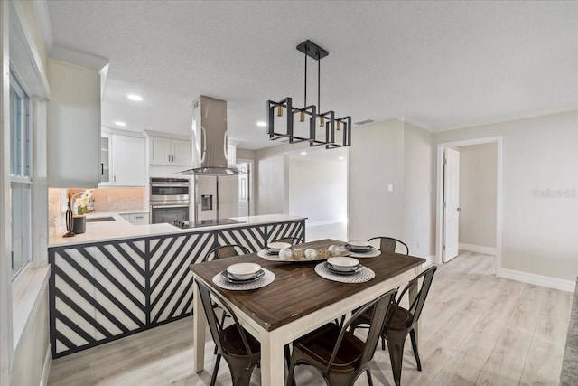 dining area featuring recessed lighting, baseboards, light wood-style floors, and a textured ceiling