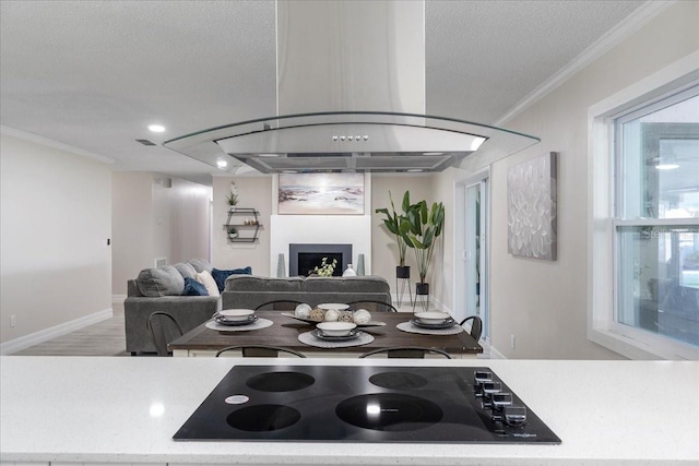 kitchen with a textured ceiling, black electric stovetop, and ornamental molding