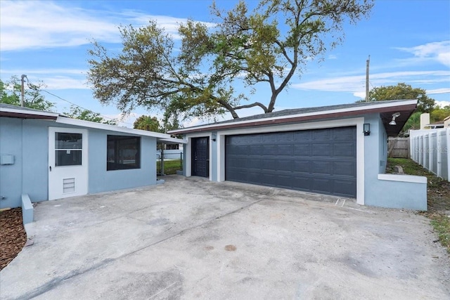 detached garage featuring fence