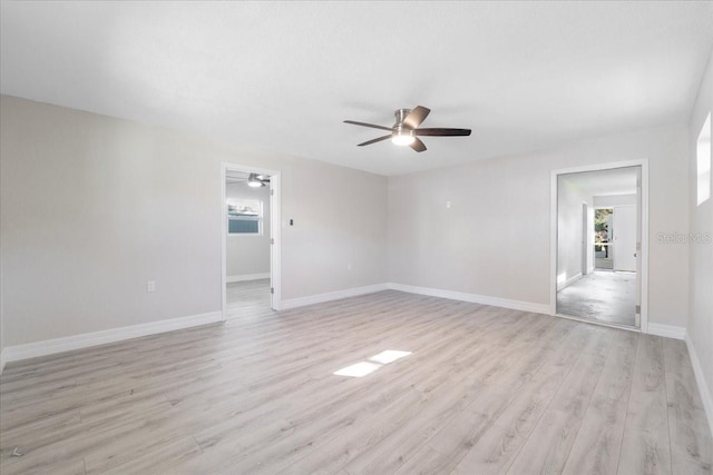 empty room featuring light wood-type flooring, plenty of natural light, baseboards, and a ceiling fan