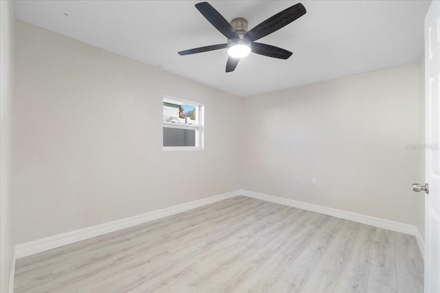 spare room with a ceiling fan, light wood-style floors, and baseboards