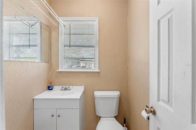 1021 Mare Bello Dr, Winter Park, FL 32792 - half bathroom featuring vanity, a textured wall, and toilet