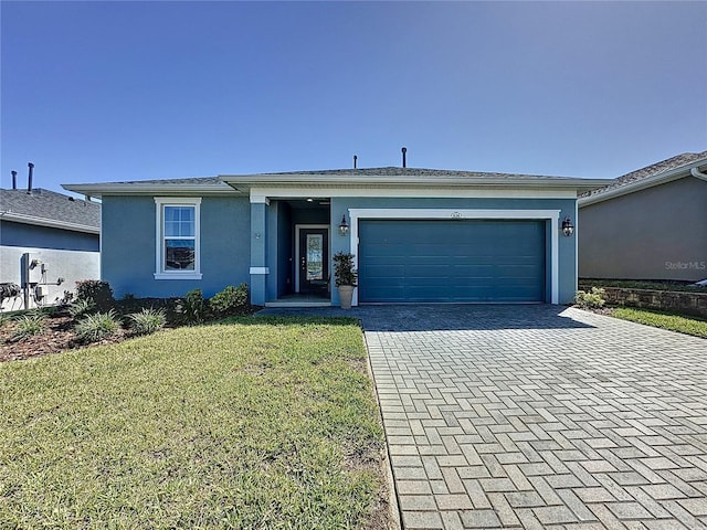 ranch-style home with stucco siding, a front yard, decorative driveway, and a garage