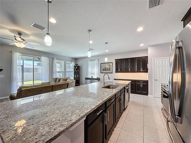 kitchen featuring visible vents, a sink, open floor plan, appliances with stainless steel finishes, and light tile patterned floors