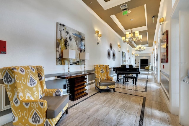 living area featuring a tray ceiling, a notable chandelier, ornamental molding, and tile patterned flooring