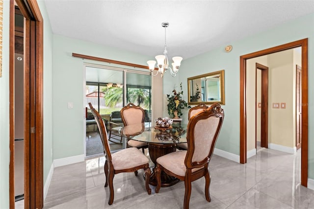 dining room featuring baseboards, a notable chandelier, and marble finish floor