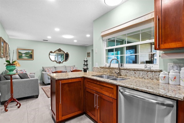 kitchen with light stone counters, visible vents, a sink, stainless steel dishwasher, and open floor plan