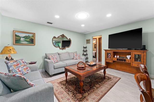 living area featuring recessed lighting, visible vents, and baseboards