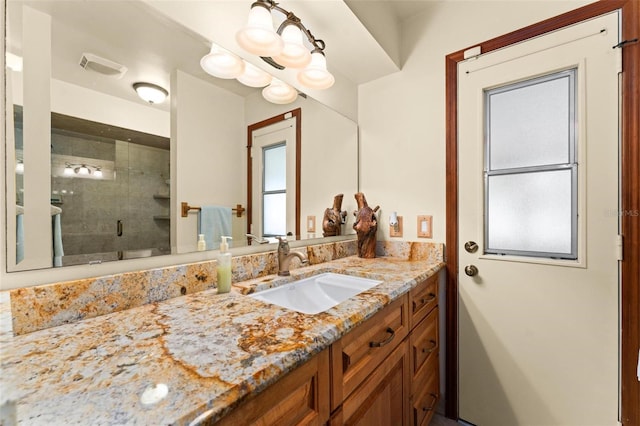 bathroom featuring vanity, a shower stall, and visible vents