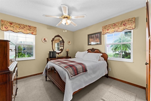 carpeted bedroom with baseboards, a textured ceiling, and ceiling fan