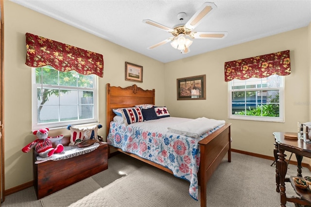 carpeted bedroom featuring ceiling fan and baseboards