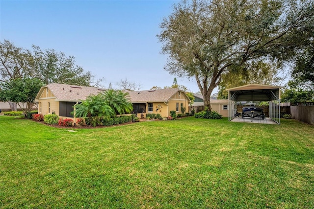 view of yard with a patio area, a carport, and fence