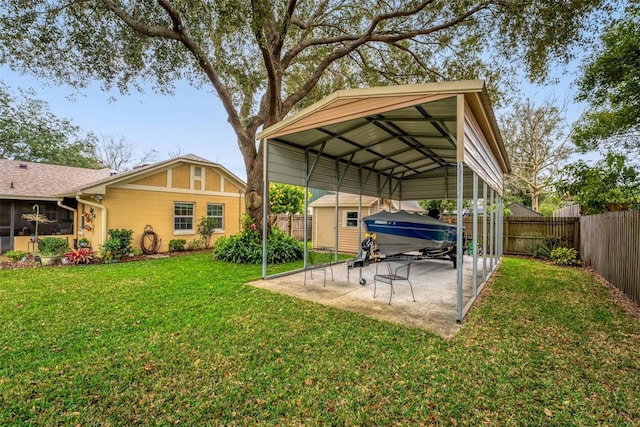 exterior space with a patio area, a carport, a fenced backyard, and an outdoor structure