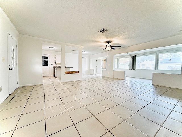 unfurnished living room with light tile patterned floors, visible vents, a textured ceiling, and a ceiling fan