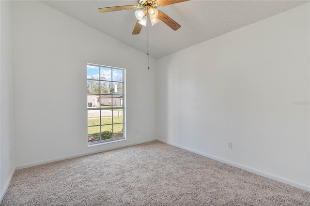 carpeted empty room featuring baseboards, lofted ceiling, and a ceiling fan