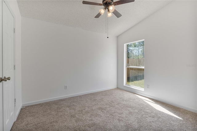 empty room with baseboards, carpet, vaulted ceiling, and a textured ceiling