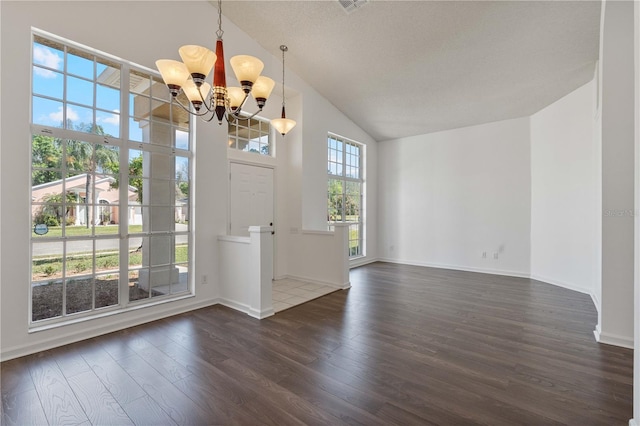 entrance foyer with dark wood finished floors, an inviting chandelier, baseboards, and high vaulted ceiling