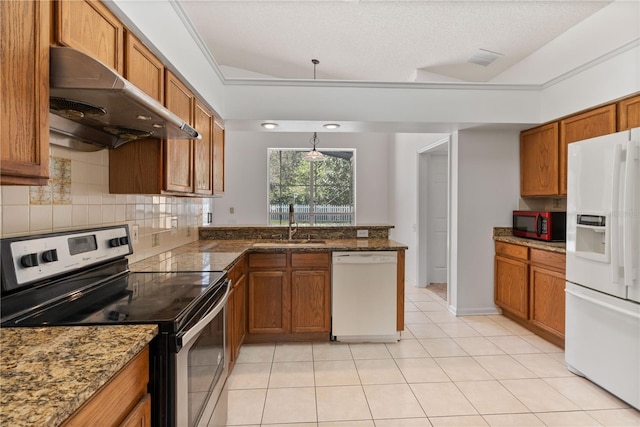 kitchen with white appliances, light tile patterned floors, brown cabinetry, under cabinet range hood, and backsplash