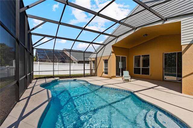 view of swimming pool with a patio, fence, a fenced in pool, and a lanai