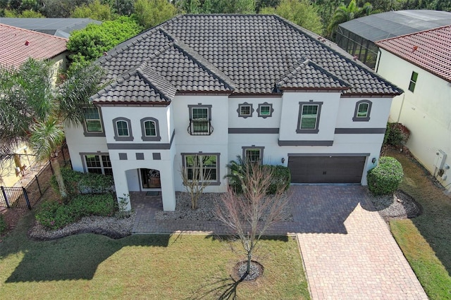 view of front facade featuring stucco siding, a tiled roof, and decorative driveway