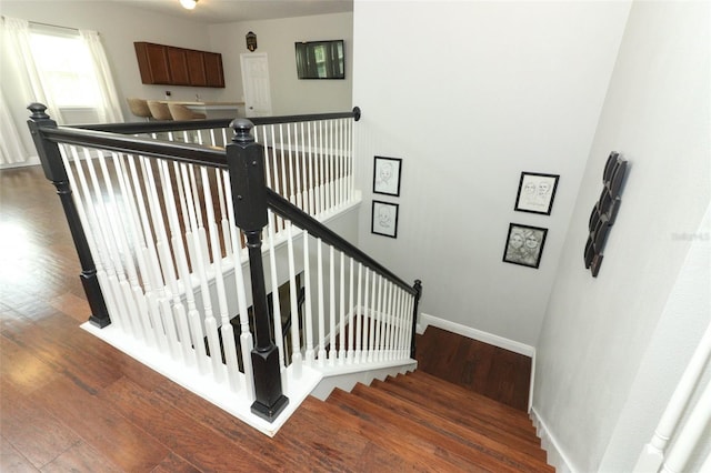 stairway with baseboards and wood finished floors