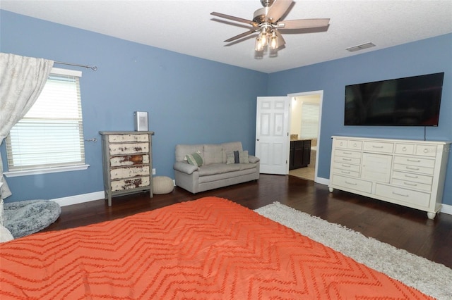 bedroom featuring visible vents, wood finished floors, connected bathroom, baseboards, and ceiling fan