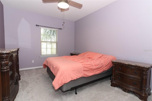 bedroom featuring baseboards, light colored carpet, and ceiling fan