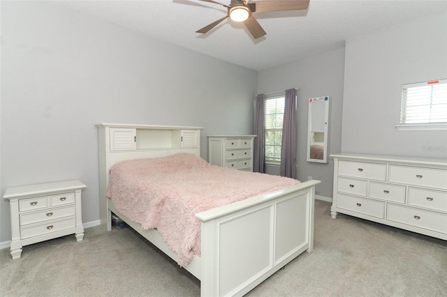 bedroom with multiple windows, light carpet, baseboards, and a ceiling fan