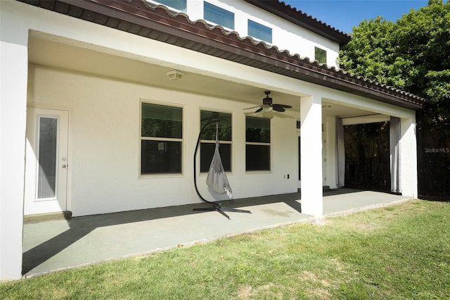 exterior space with a yard, stucco siding, a patio, and ceiling fan