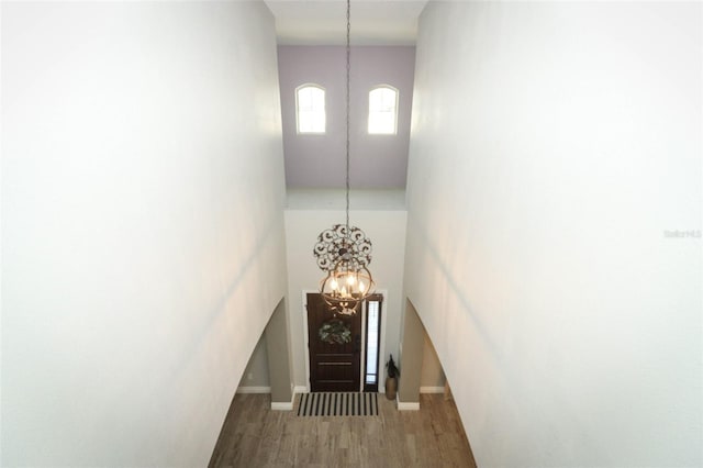 interior space with a chandelier, baseboards, and wood finished floors