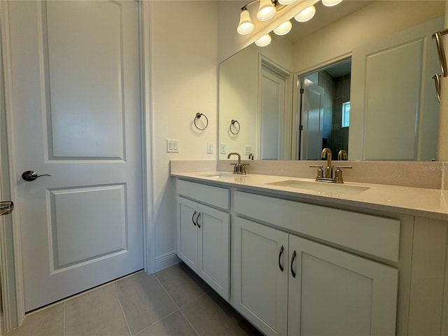 bathroom with a sink, double vanity, and tile patterned floors