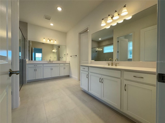 bathroom featuring a sink, visible vents, plenty of natural light, and a stall shower