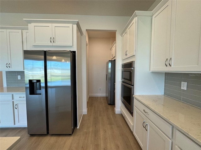 kitchen featuring light wood-type flooring, stainless steel appliances, and white cabinetry