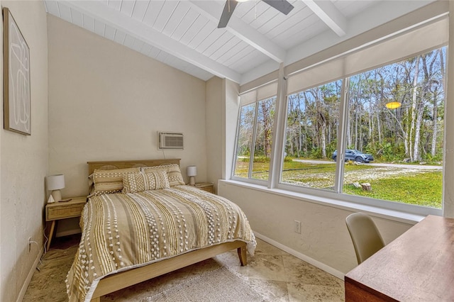 bedroom featuring baseboards, vaulted ceiling with beams, an AC wall unit, stone finish floor, and a textured wall