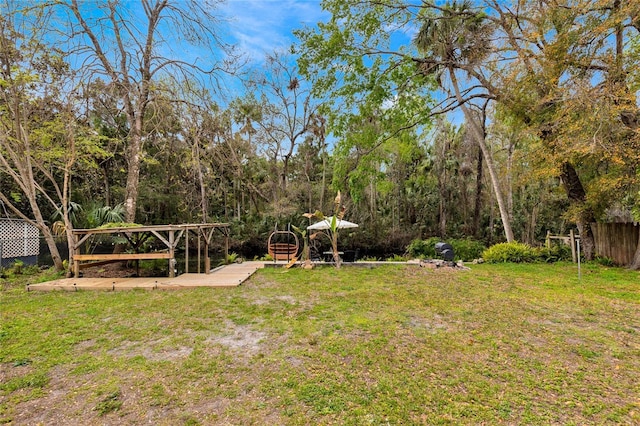 view of yard featuring fence and a forest view