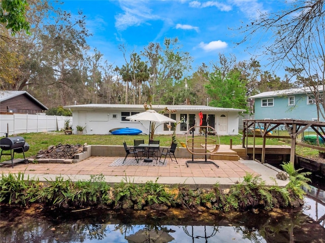 back of property with a yard, a patio area, and fence