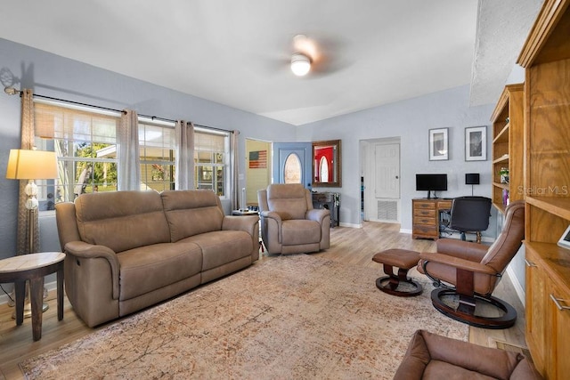 living room with baseboards, a ceiling fan, and wood finished floors